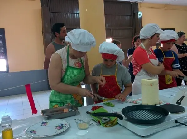 Una pareja prepara la brocheta de pescado