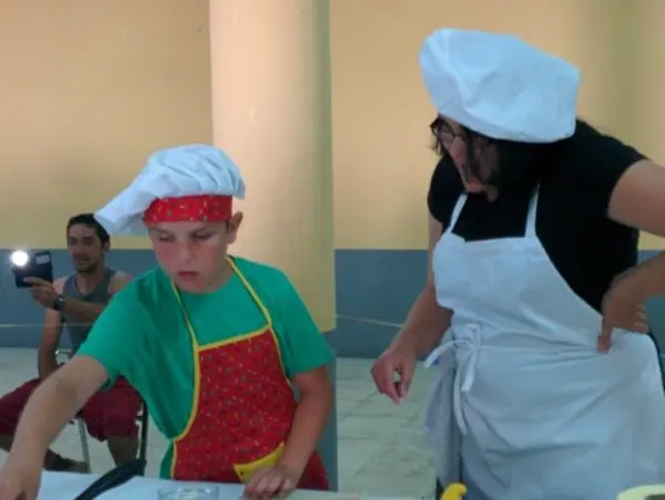 Un joven cocinero atiende las instrucciones de su tutora
