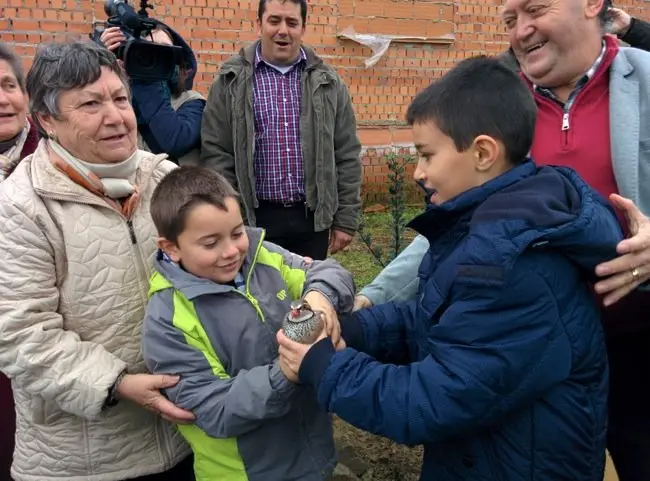 Dos niños sueltan una perdiz en la Fiesta del ÁRbol 2016 en Villanueva de la Sierra