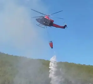 Un helic&oacute;ptero descarga el bambi sobre el incendio de Acebo. IMAGEN ROSA LORO