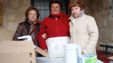 Paula, Nati y Mari Carmen sirven la chocolatada en Villasbuenas
