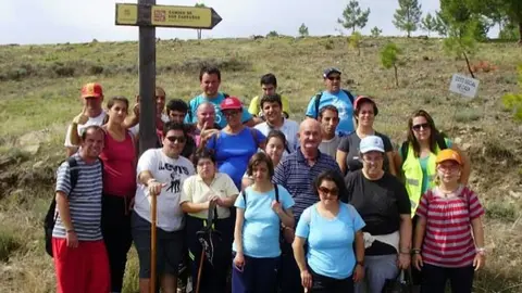 Los excursionistas posan ante la señal
