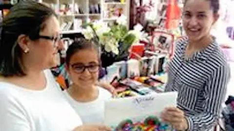 Elena Moreno con su hija María, la ganadora, y Yolanda González en Librería Neruda