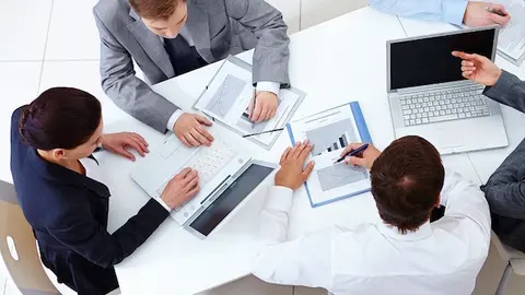 Above view of business team sitting around table and working